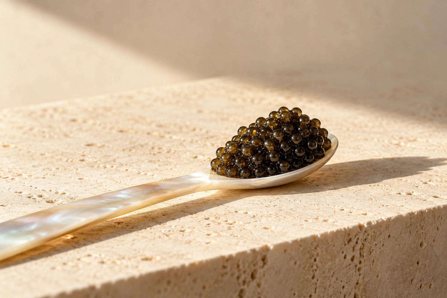 Caviar on a mother-of-pearl spoon in warm light